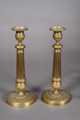pair of antique brass candlesticks on a grey background