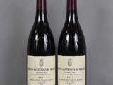 two bottles of wine sitting on top of a table next to each other