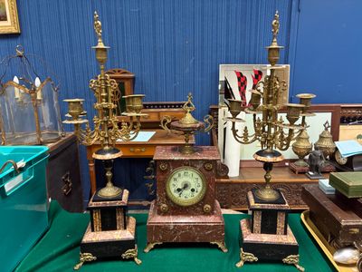 une table sur laquelle se trouvent une horloge et d'autres objets anciens