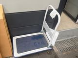 une plate-forme métallique recouverte d'un tapis bleu sur le trottoir