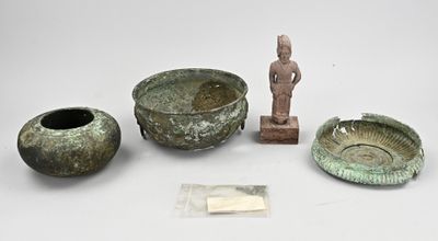Plusieurs objets anciens sont exposés sur une surface blanche