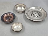 three silver dishes and a silver bowl on a table