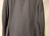 the back of a gray jacket hanging on a hanger