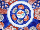 a blue and red plate with orange flowers on it