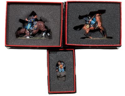 three miniature figurines of a man riding a horse in a box