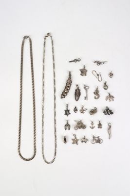 un assortiment de bijoux en argent posés sur une surface blanche, sur fond blanc
