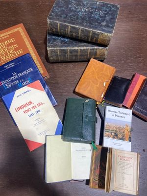 Plusieurs livres sont posés sur une table à côté d'un portefeuille
