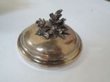 a silver plate with a flower on it on a table
