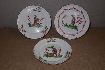 trois assiettes ornées de motifs représentant des oiseaux et des fleurs, posées sur une table