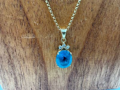 un gros plan d'un collier orné d'une pierre bleue