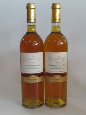 two bottles of wine sitting next to each other on a white surface