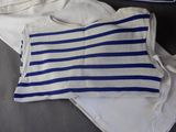 a blue and white striped shirt and a pair of white pants