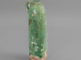 an image of a green vase with a handle on a gray surface