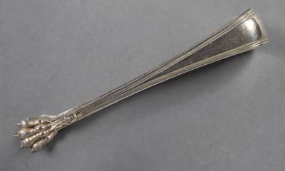 a silver spoon with a flower on it on a table