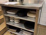 de nombreuses assiettes et casseroles sur l'étagère de la cuisine