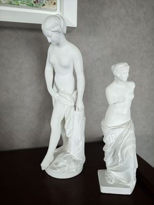 deux statues représentant un homme et une femme posées sur une table