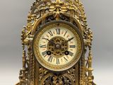 a gold clock that is sitting on top of a table
