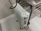 un radiateur posé au sol à côté d'un lavabo