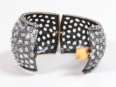 une photo d'un bracelet manchette noir et blanc orné de pierres bleues et blanches