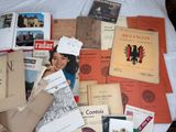a lot of books on a bed with a white comforter
