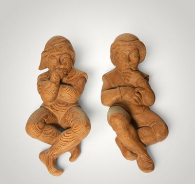 two carved figurines of a man and a woman sitting on their knees