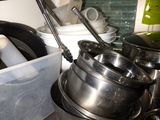 des casseroles et des poêles sont empilées sur le plan de travail de la cuisine
