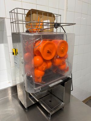 une machine remplie d'oranges, posée sur un comptoir