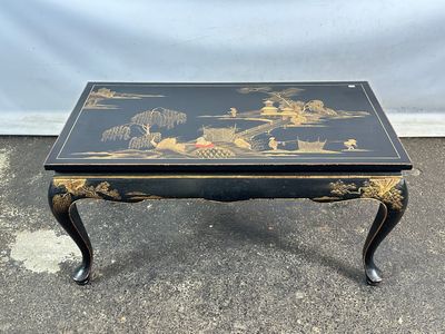 une table basse noire et dorée décorée d'oiseaux et de fleurs