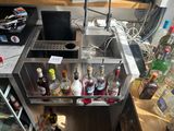 de nombreuses bouteilles d'alcool posées dans un évier en métal