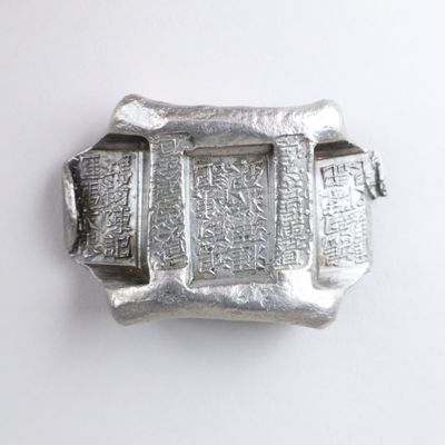 silver buckle with writing on it on a white surface