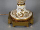 a white and gold vase with a gold decoration on it
