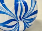 a blue and white striped glass vase on a table