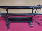 two samurai swords on a stand on a table