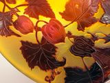 a glass bowl with leaves and berries on it