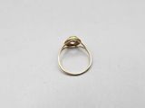 a close up of a gold ring on a white surface