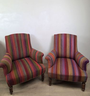 deux chaises rayées aux couleurs vives, placées l'une à côté de l'autre sur un parquet