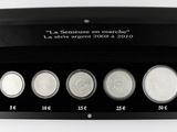 three silver coins are in a black box on a white surface