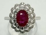 gros plan d'une bague avec une pierre rouge entourée de diamants blancs