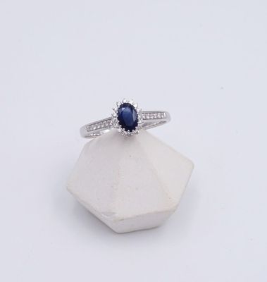 une image représentant une bague ornée d'un saphir bleu posé sur une pierre blanche