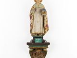 a wooden statue of a woman with a crown on top of a pedestal