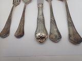 five silver spoons and a knife on a table