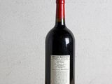 a bottle of red wine sitting on a wooden table