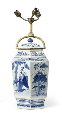 a blue and white vase with a brass handle