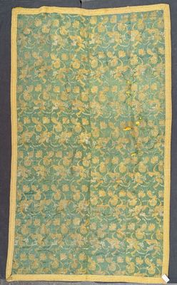 an old green and yellow cloth with yellow flowers on it