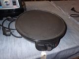 an image of a crepe pan on a table next to a toaster and a toaster