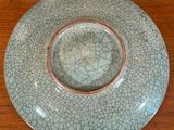 a cracky plate on a wooden table with a brown rim