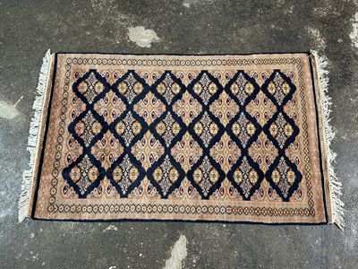 un tapis bleu et beige posé sur un sol en béton