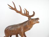 statue of a brown deer with antlers on a white background