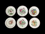 six assiettes ornées de motifs d'oiseaux et de fleurs sur fond noir