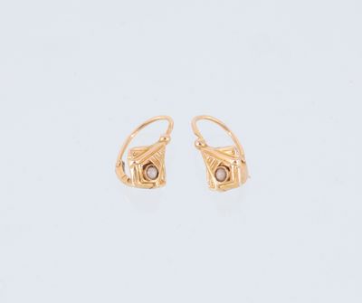 une paire de boucles d'oreilles en or sur fond blanc